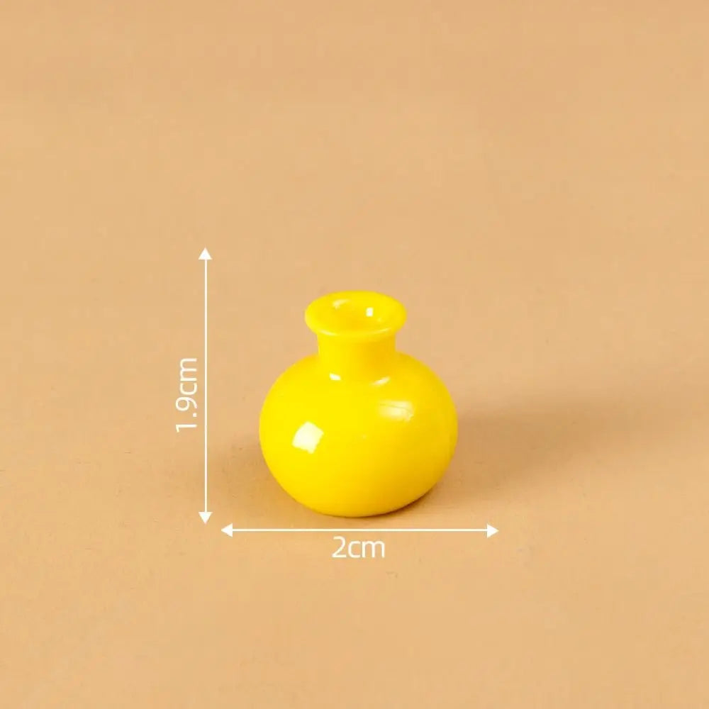 A small, bright yellow resin vase with a round body and a flared opening.
