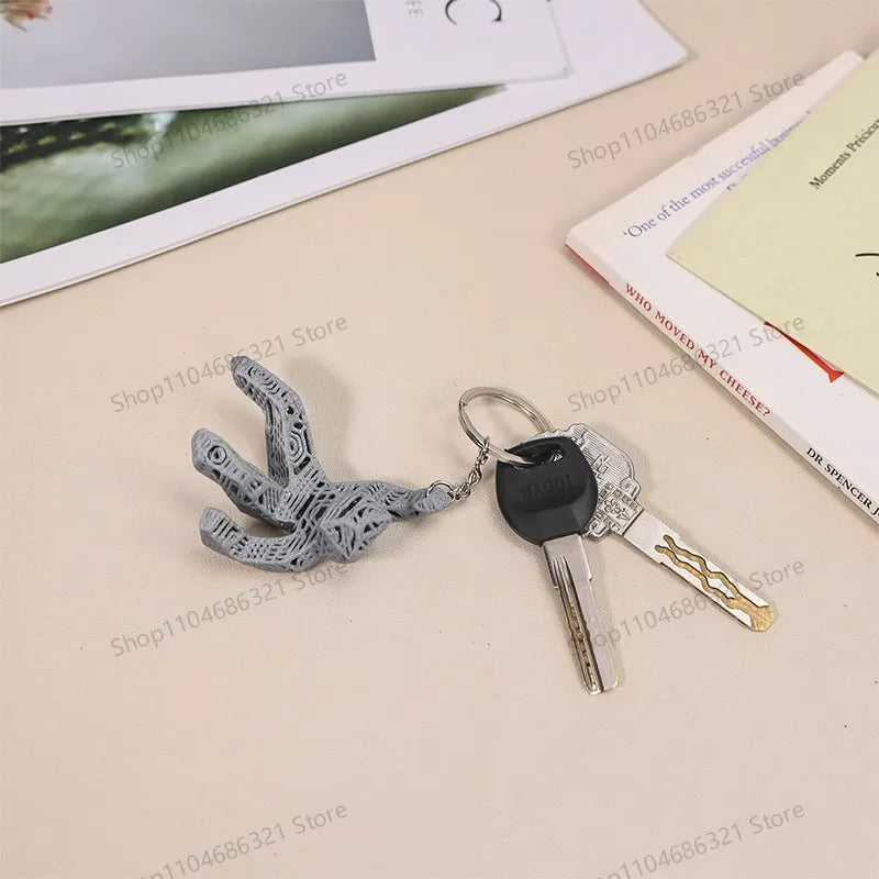 A collectible figurine set featuring a gray, textured figure and a silver key pendant.