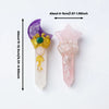 A purple crystal wand with a green charm and a pink crystal wand featuring a pearl and floral design.
