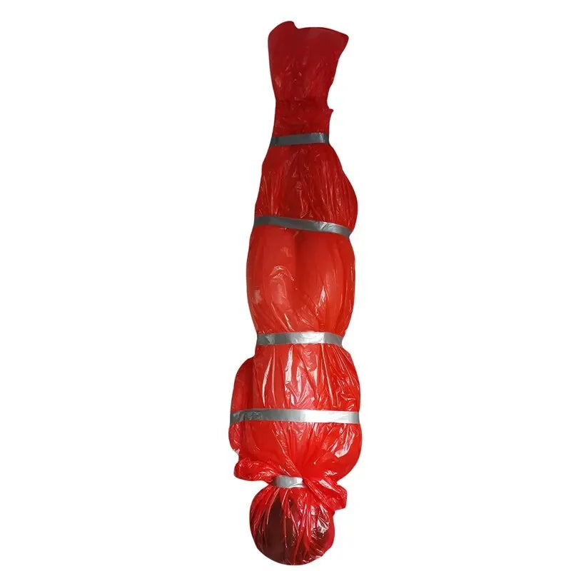 A realistic dead victim prop wrapped in red plastic and secured with silver bands for Halloween decor