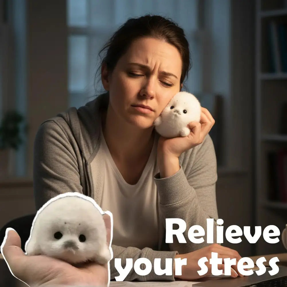 A woman holds a white seal plush keychain, looking stressed while working at a desk.