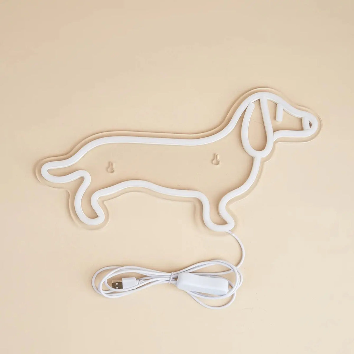 A white neon sign shaped like a dog outline is shown with its USB power cord.