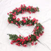A garland of pink and red silk roses on a green vine used for wedding or home decor.