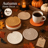A set of four crochet pumpkin coasters in various natural tones displayed on a wooden surface.