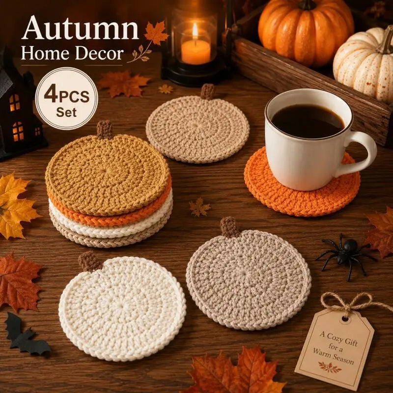 A set of four crochet pumpkin coasters in various natural tones displayed on a wooden surface.