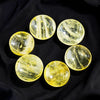 Nine polished yellow citrine crystals arranged in a circle on a black background