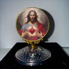A round religious ornament featuring a depiction of Jesus with a glowing heart surrounded by light.