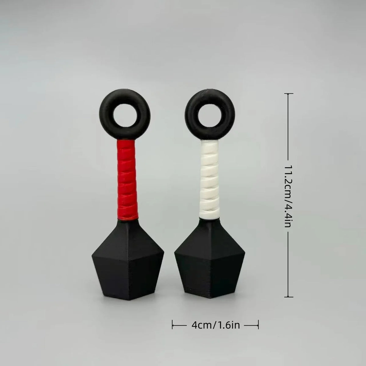 A pair of black and red ninja darts refrigerator ornaments with circular handles and pointed bases.