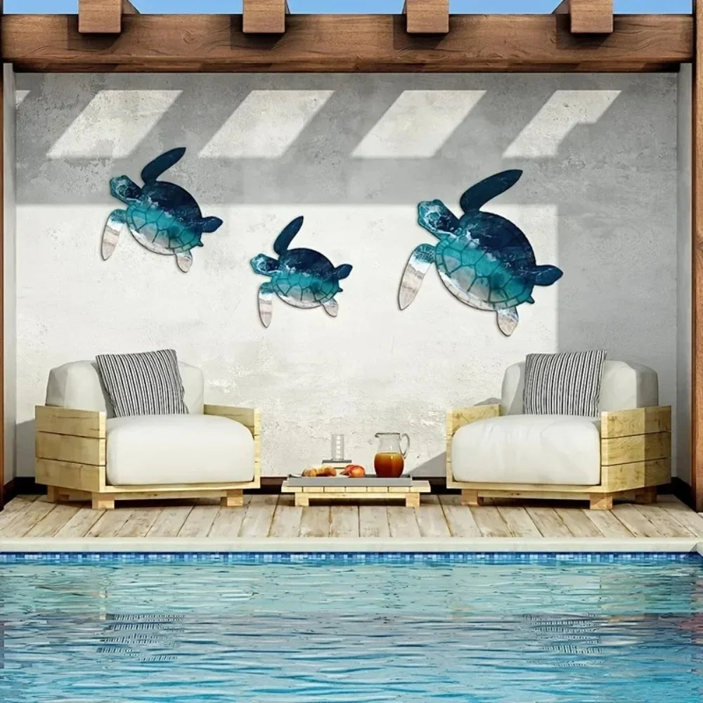 Rustic iron wall art sculpture featuring three teal and blue sea turtle silhouettes displayed on a concrete wall above a wood