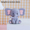 A small, gray cartoon elephant figure with pink ears sitting on a white surface.