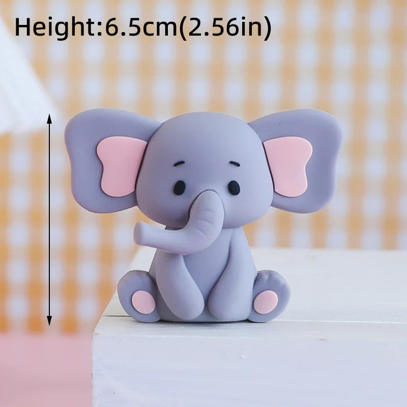 A small, gray cartoon elephant figure with pink ears sitting on a white surface.