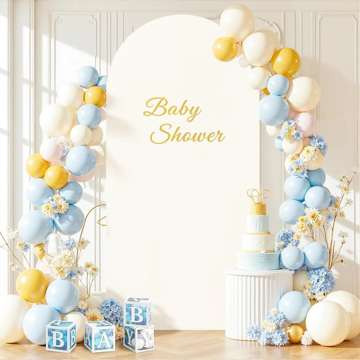 A white arch backdrop decorated with balloons in shades of yellow, cream, and blue for a baby shower.