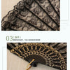 Close-up of a black lace folding fan with gold accents and a decorative gold pin.