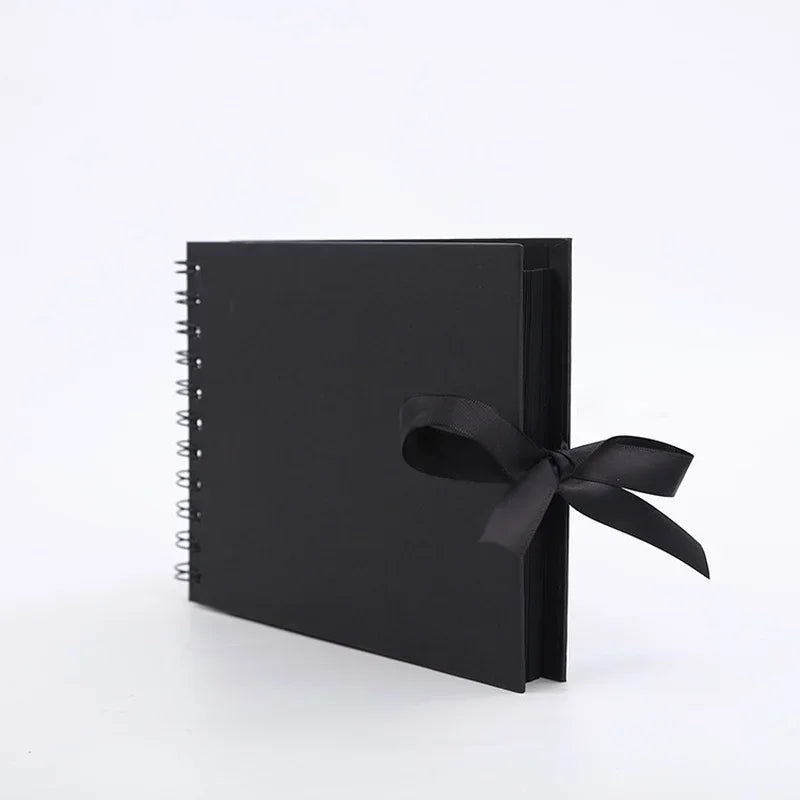 A black premium DIY scrapbook photo album with a black ribbon tied on the cover.