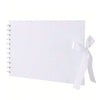 Un cuaderno cuadriculado blanco con encuadernación en espiral y una cinta blanca atada en la cubierta.