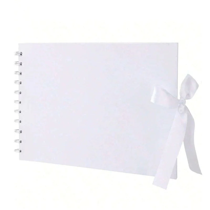 Un cuaderno cuadriculado blanco con encuadernación en espiral y una cinta blanca atada en la cubierta.