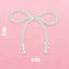 A white pearl bow cake topper with a loop design shown against a pink background.