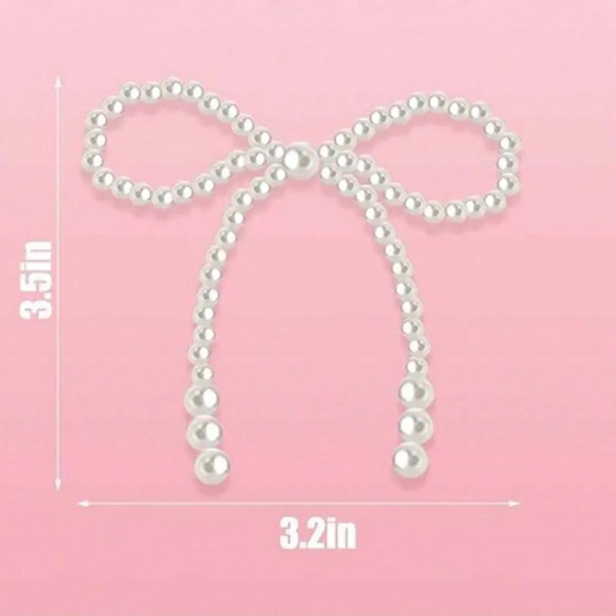 A white pearl bow cake topper with a loop design shown against a pink background.