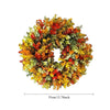 A circular wreath made of artificial flowers in shades of orange, yellow, and green for home decor