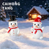 Two white resin snowman figurines, one wearing a black top hat and the other a red hat, are placed in a snowy outdoor setting