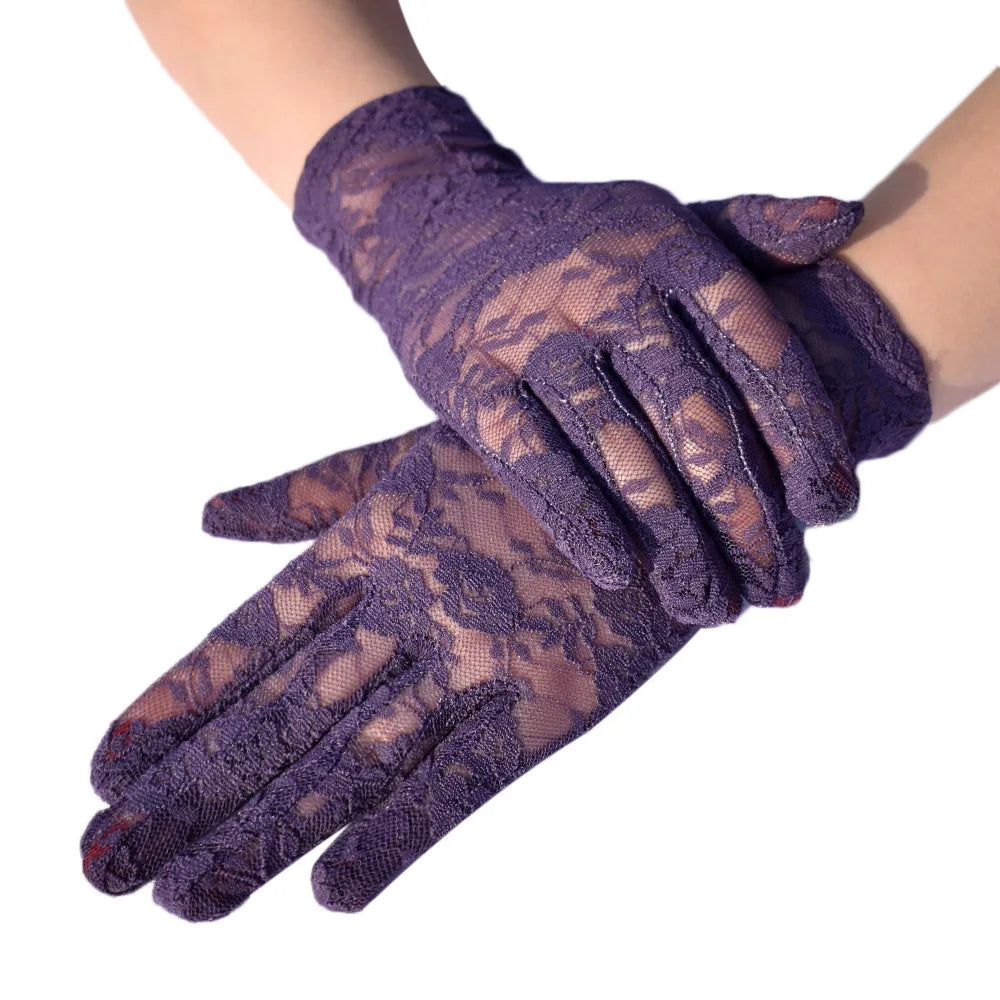 A pair of purple sheer lace gloves worn on a wrist.