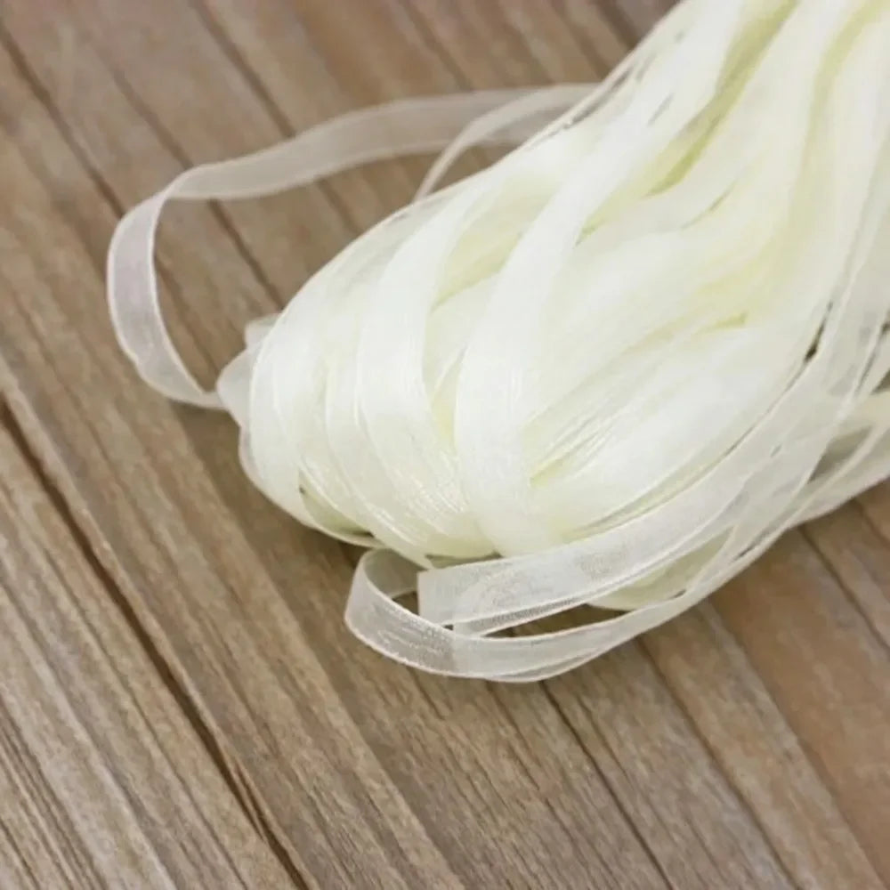 A bundle of white decorative fishtail yarn ribbon laid on a wooden surface.