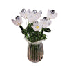 A bouquet of hand-blown glass flowers with white and pink petals in a clear glass vase.