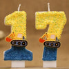 Two yellow glitter candles shaped like the number 1 and 7, featuring construction excavators on the base.