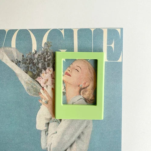 A light green magnetic photo frame displaying a close-up portrait of a woman against a teal background.