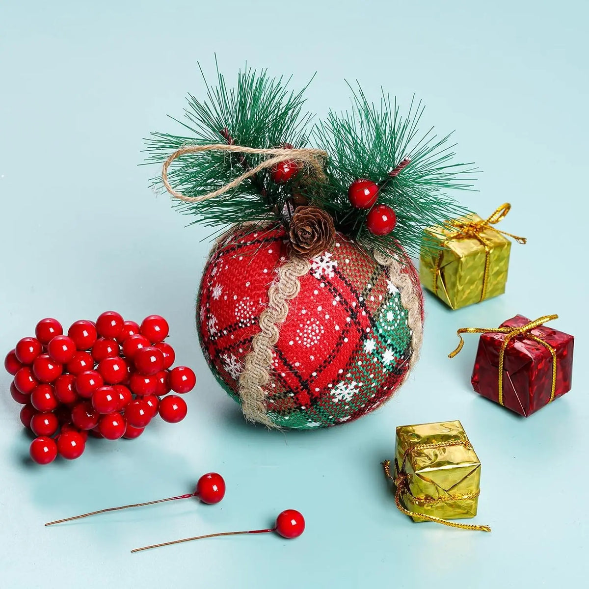 Arreglo festivo de bayas de acebo artificiales atadas con cuerda y envueltas en follaje verde para decoración navideña.