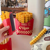 A hand holds a red clip container filled with yellow french fry shaped sealing clips.