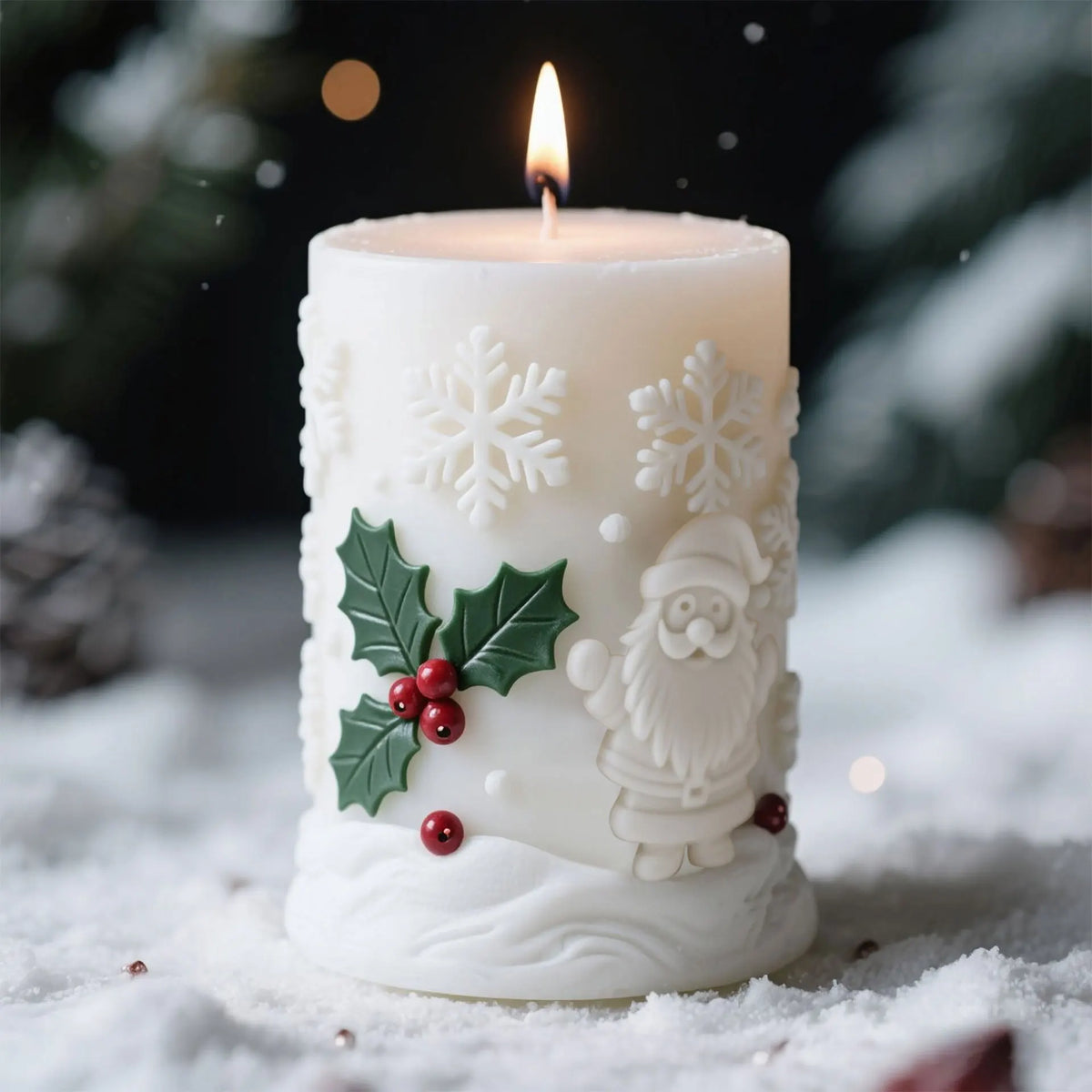 White silicone candle with a lit flame and carved Christmas figures resting on snow.