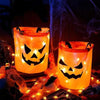 Two glowing orange pumpkin tote bags with carved faces illuminate a dark background.