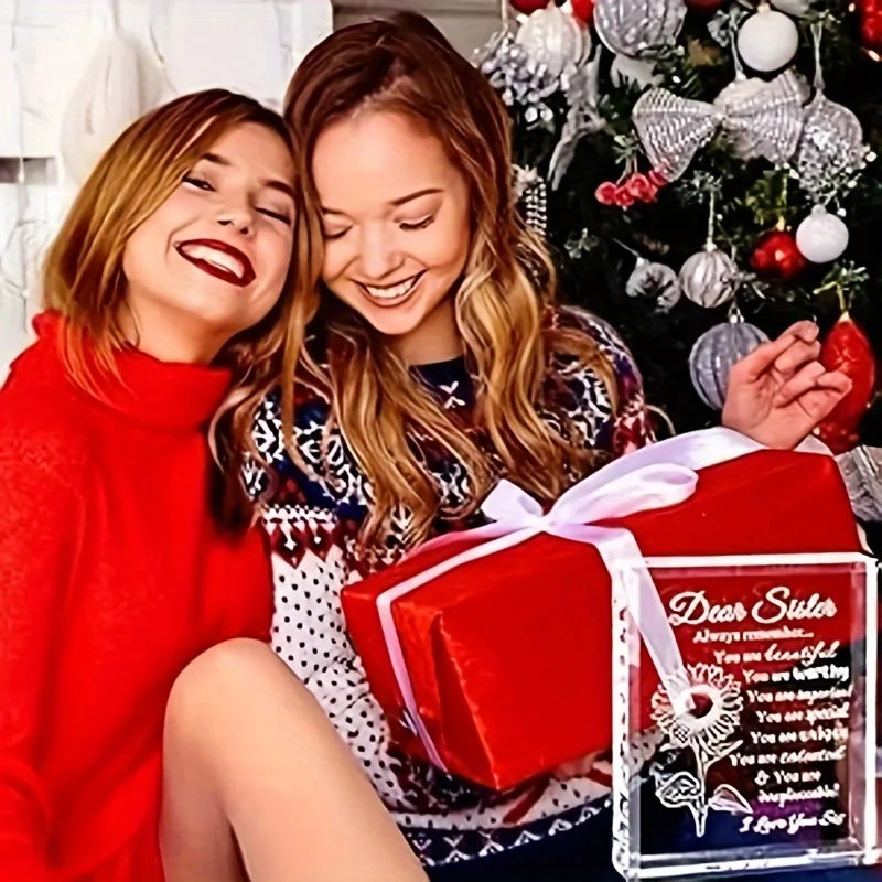 Two young women smiling while holding a red gift box decorated with a personalized crystal keepsake.