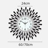 A modern minimalist metal wall clock with a black and silver sunburst design.