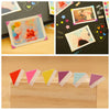A collection of colorful PVC photo corner protectors in various pastel shades arranged on a wooden tray.