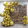 A large balloon garland made of metallic gold balloons against a textured silver background.