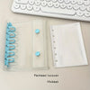 A clear plastic binder cover and a white sheet protector are shown next to a computer keyboard.
