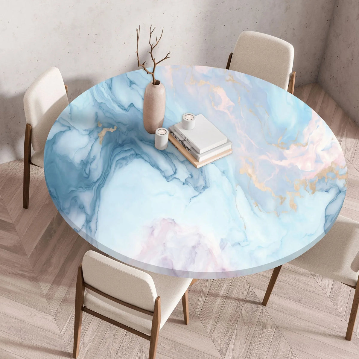 A round table set for dining featuring a marble print tablecloth with blue and pink tones on a light wood floor.