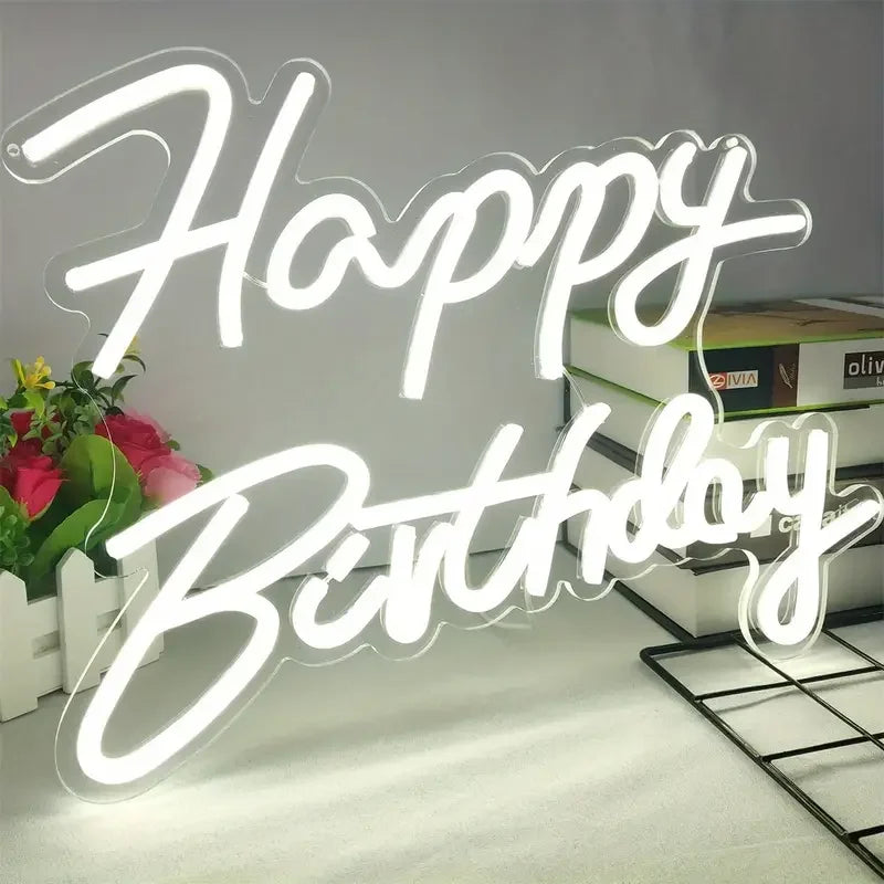 A glowing neon sign spelling out Happy Birthday on a white background.