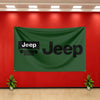 A dark green Jeep banner hangs on a red wall with white ceiling lights and potted plants below.