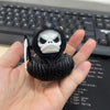 A black 3D printed statue of a Grim Reaper duck with a skull hood is held in a hand.