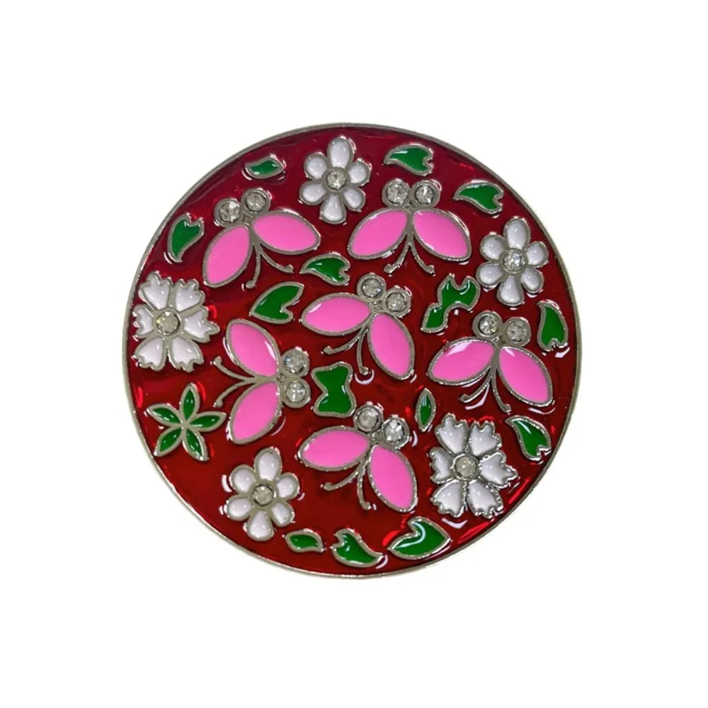 A round, red decorative piece featuring embossed floral designs in pink and white crystal.