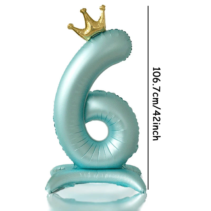 A large light blue foil number balloon shaped like the number 6 with a gold crown topper.