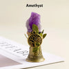 A purple amethyst crystal mounted on a brass bell with a copper finish