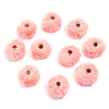 Plusieurs perles pompon roses et duveteuses avec des éléments métalliques sont présentées sur un fond blanc.