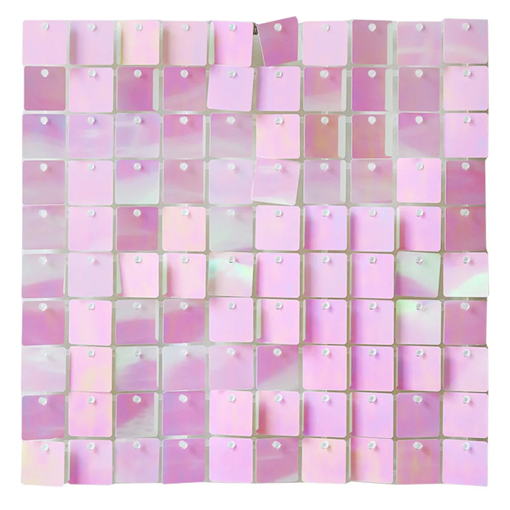 A grid of square, iridescent pink and purple glitter panels used as a wall backdrop.