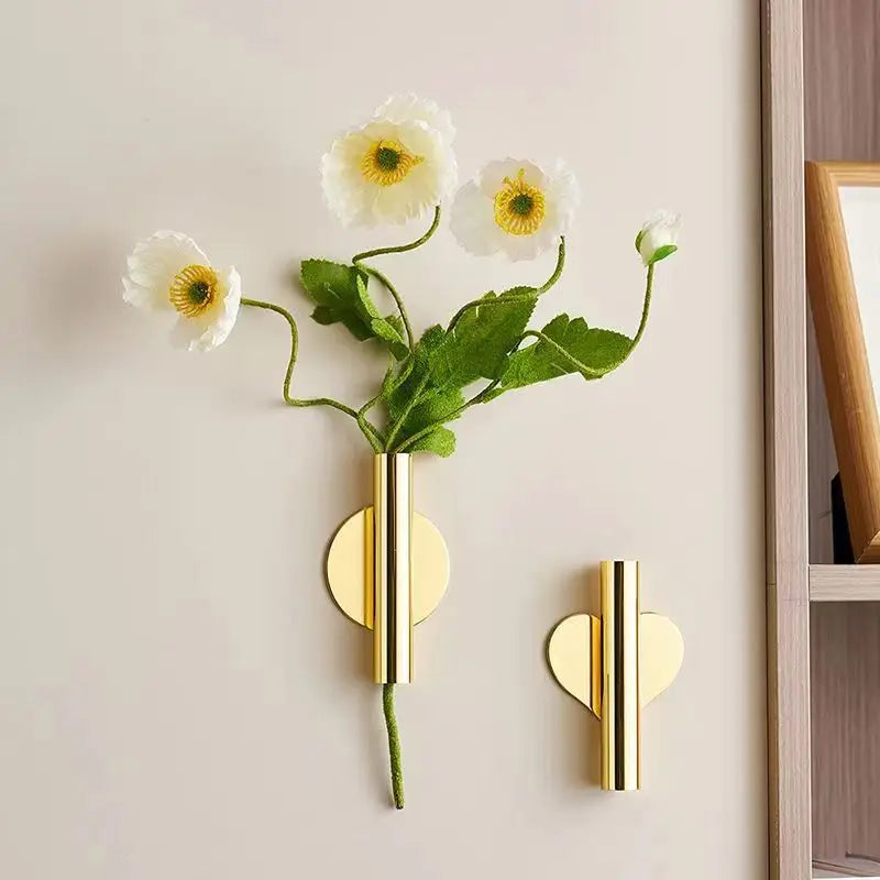 Wandmontierte Blumenvase mit grünem Stiel und weißen, gelben Blumen, goldene Akzente.