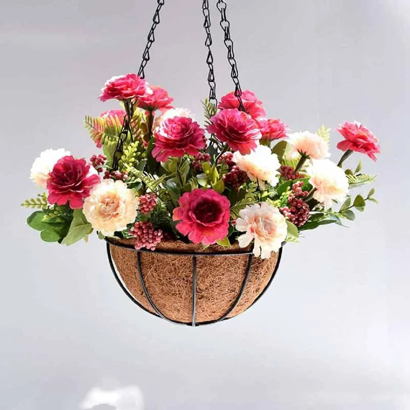 A metal hanging basket filled with pink and white flowers, suspended by chains.
