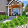 Lush green artificial Boston ferns and shrubs planted in a garden bed in front of a modern house.